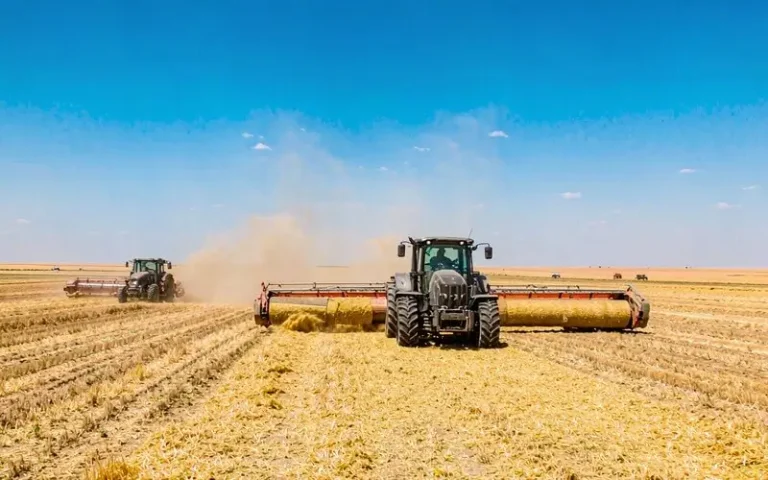 Red tractor working in green field with durable lawn and agriculture belts